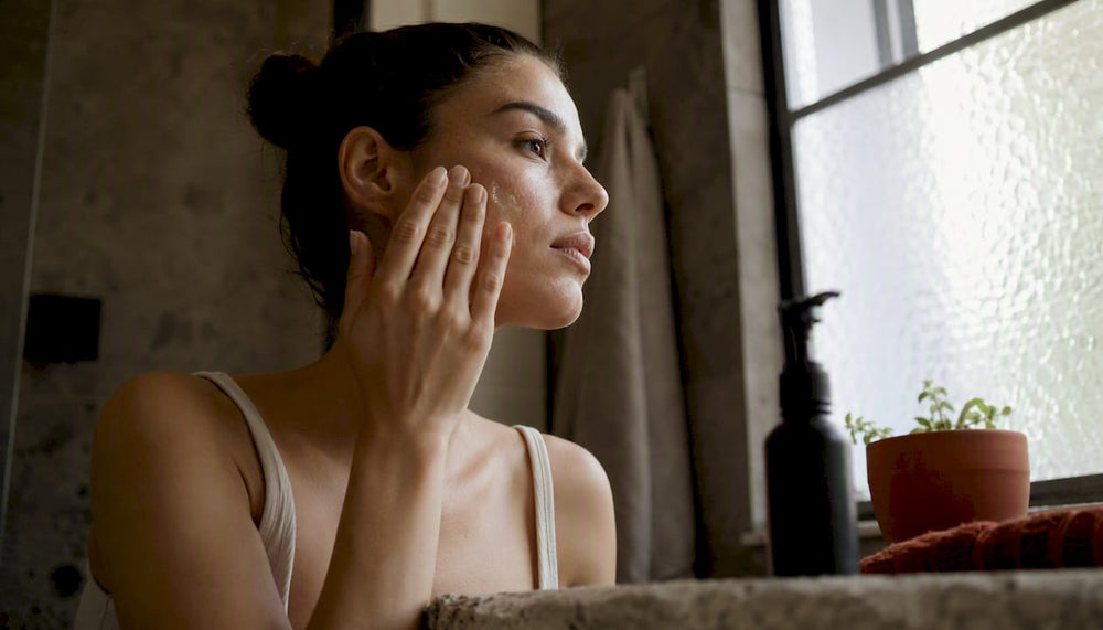 Hands applying skincare serum to face