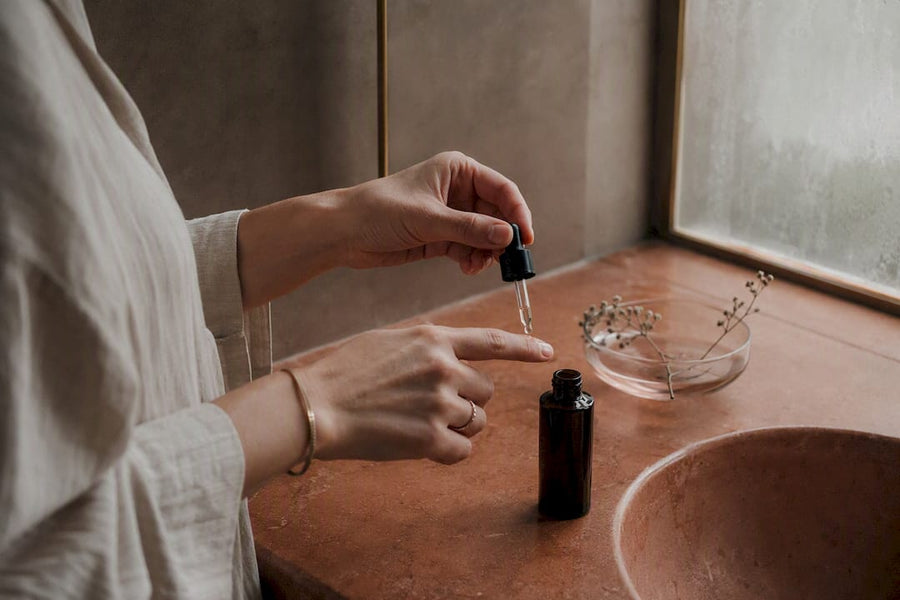 Hands applying copper peptide serum