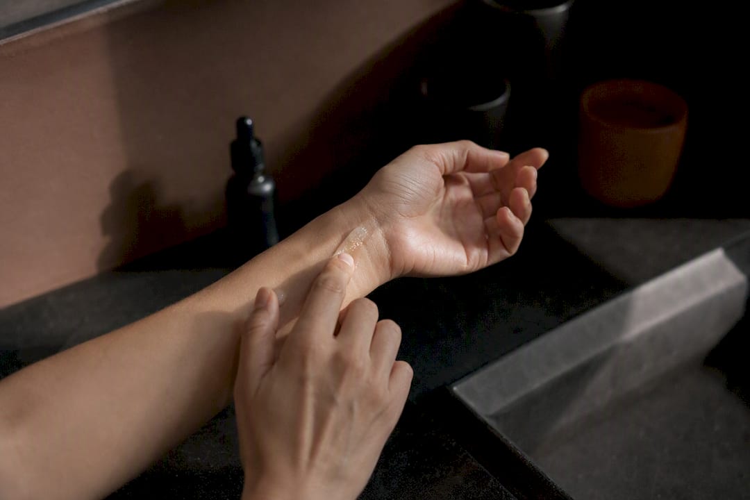 Hands applying clear serum for skincare