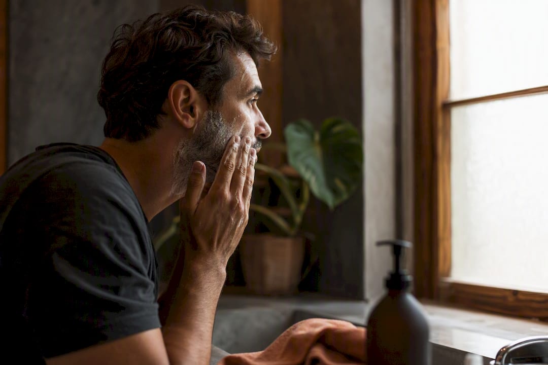 Man cleansing face in bathroom