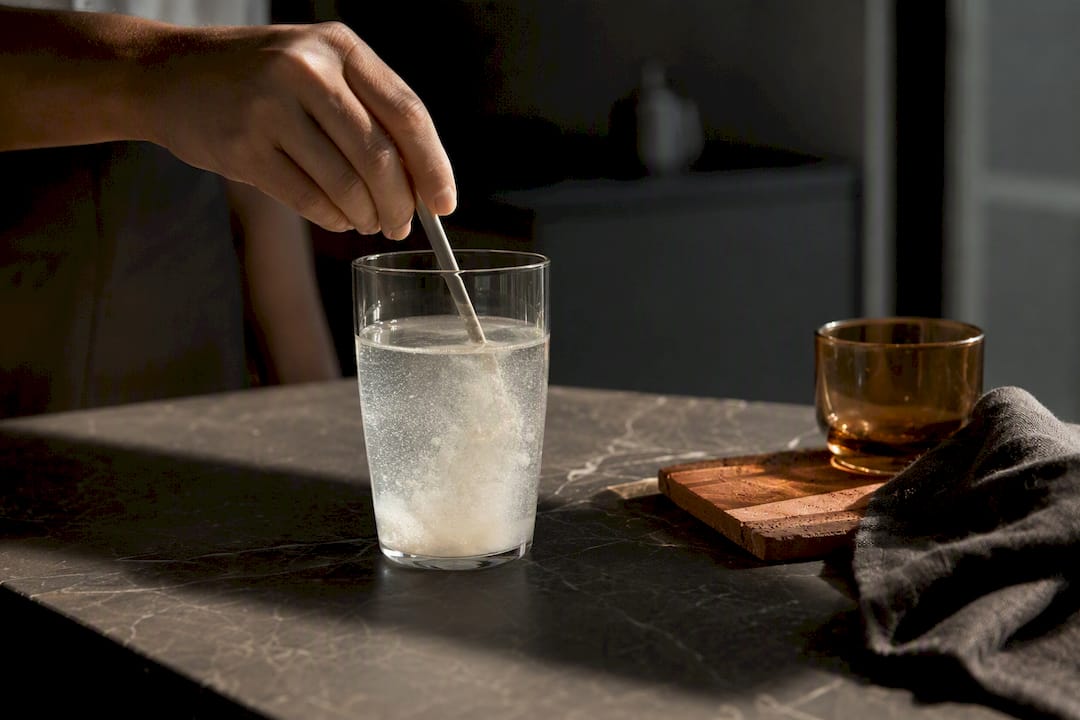 Hand stirring collagen powder into water