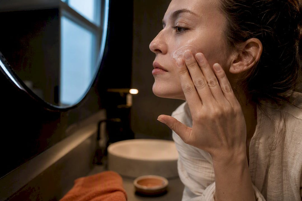 Hands applying gentle moisturizer to cheek