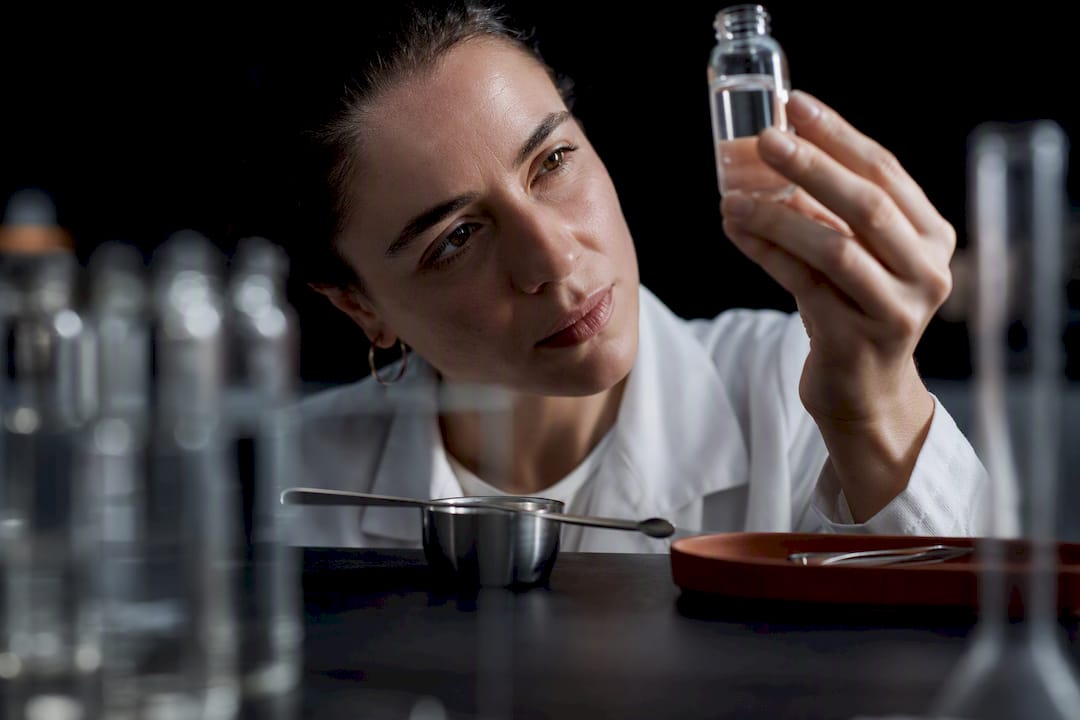 Formulator inspecting peptide solution in laboratory