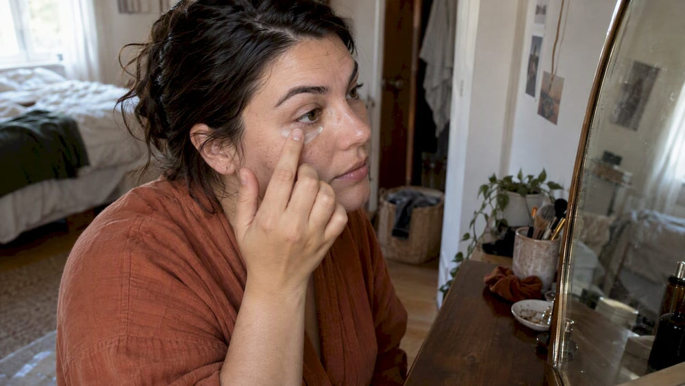 Woman gently applying skincare beneath one eye