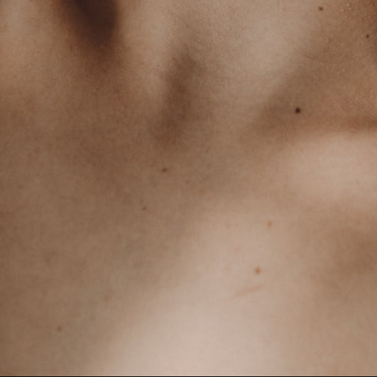 Close-up of a person's neck and shoulders with a blurred background