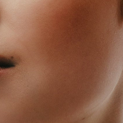 Woman with styled hair and makeup against a white background